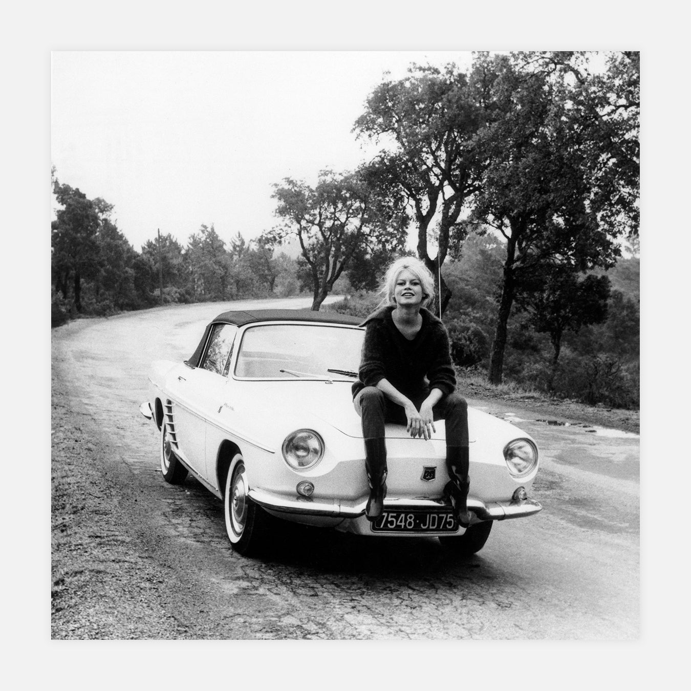 Brigitte Bardot assise sur sa voiture - Photo d'art
